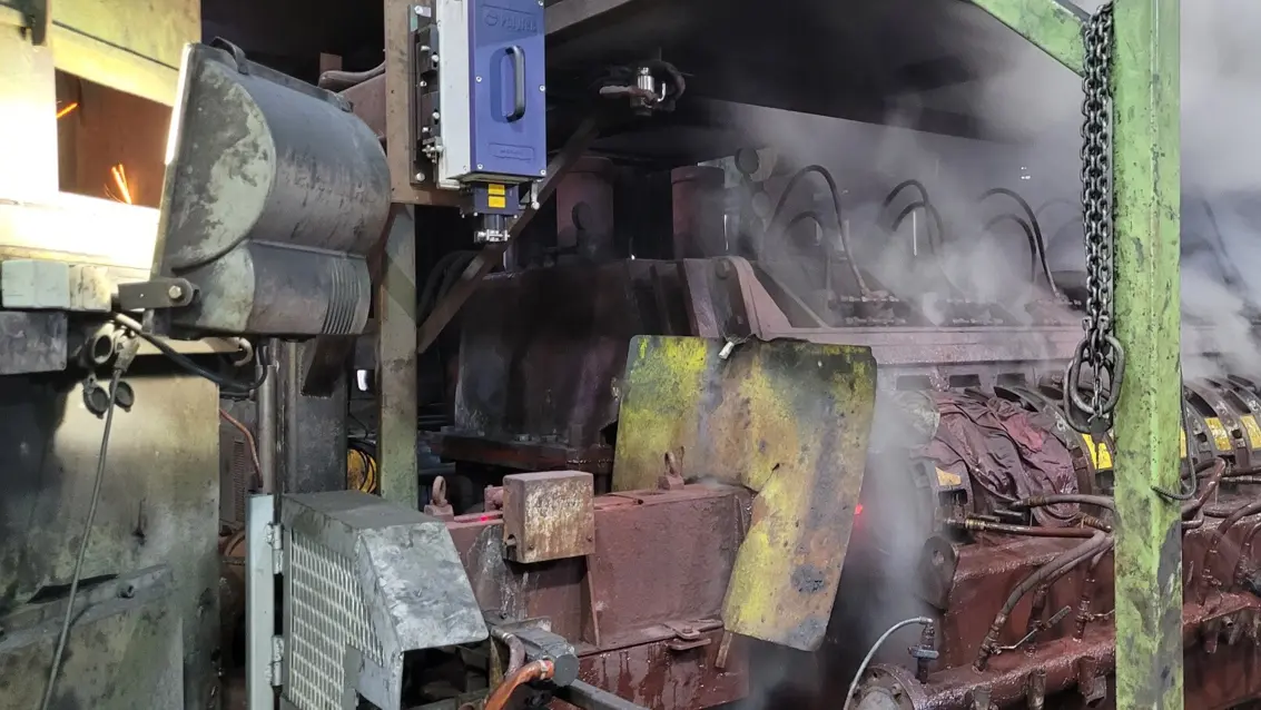 Industrial machinery in a steel mill releasing steam during hot rolling, highlighting heavy metal production processes.