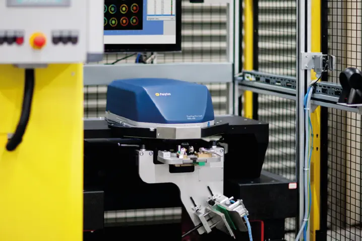 Blue Polytec optical 3D surface profiler scanning precision mechanical parts in a controlled industrial environment.