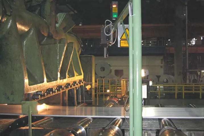 Industrial metal sheet rolling process with laser surface velocimeter for precise non-contact velocity measurement.