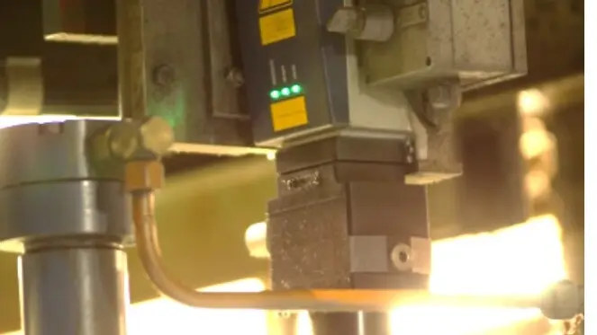 Polytec laser Doppler sensor with green indicator lights measuring speed precisely in an industrial production environment.