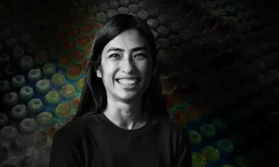 Smiling woman with long dark hair in front of a textured 3D surface profile visualization highlighting advanced microscope-based metrology.