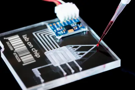 微流控芯片实验室卡匣正接受红色液体注入，展示Lab-on-Chip微通道结构及流体控制技术